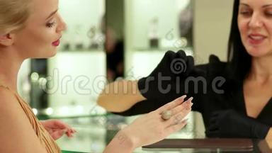 金戒指与钻石，一个女孩想在珠宝店买一个大金戒指，选择珠宝中的
